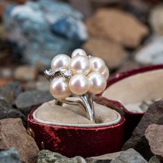 This prominent cluster style ring is accented with nine (9), post set, cultured saltwater pearls, three (3), prong set, round brilliant cut diamonds and four (4), bead set, round single cut diamonds. The ring measures 21.9mm at the top, rises 14.5mm above the finger, tapering to 1.7mm wide and 1.1mm thick at the base of the shank. This ring is currently a size 5.25. Elegant Diamond White Multi-stone Cluster Ring, Elegant Cluster Pearl Ring For Formal Occasions, Elegant Formal Cluster Pearl Ring, Fine Jewelry Pearl Ring With High Luster For Wedding, Formal Multi-stone Pearl Ring In Fine Jewelry Style, Fine Jewelry High Luster Pearl Ring For Wedding, Formal Jewelry With Rose Cut Diamonds And Pearls, High Luster Pearl Ring For Wedding, Formal Pearl Jewelry With Rose Cut Diamonds