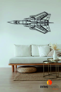 a living room with a couch, coffee table and wall decal in the shape of a jet