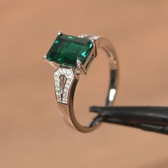 It is a lab emerald ring. The main stone is 7 mm*9  mm emerald cut.weight about 2.06 carats.The basic metal is sterling silver and plated with rhodium.To change the metal to a solid gold (white/rose) or platinum is also available, please ask for a quotation if you want.You can also go to my shop Home for more elegant rings: https://www.etsy.com/shop/godjewelry?ref=hdr_shop_menu Emerald is May birthstone More emerald rings:https://www.etsy.com/shop/godjewelry?ref=seller-platform-mcnav&section_id= Sterling Silver Emerald Ring With Baguette Cut, Baguette Cut Emerald Ring In Sterling Silver, Silver Sterling Emerald Ring With Baguette Cut, Sterling Silver Emerald Ring With Baguette Cut Center Stone, Silver Sterling Silver Emerald Ring Baguette Cut, Silver Sterling Baguette Cut Emerald Ring, Silver Emerald Baguette Cut Jewelry, Silver Sterling Silver Baguette Cut Emerald Ring, Baguette Cut Emerald Ring With Center Stone