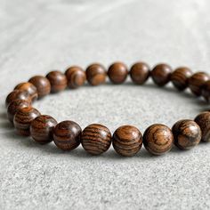 Features: ~ 6mm, 8mm or 10mm fragrant Tiger Skin Sandalwood beads ~ Strong, non-fraying elastic cord; simply slide bracelet on and off wrist ~ Comes packaged in a re-usable microfiber pouch ~ Avoid wearing in water as wood naturally fades if exposed to water To ensure the perfect fit, please use the bracelet sizing instructions found in the photo gallery. For more wood beaded bracelets please use the following link: https://www.etsy.com/ca/shop/FujiBeads?ref=shop_sugg&search_query=wood Be sure t Wooden Bead Bracelet, Tiger Skin, Slide Bracelet, Wood Bead Bracelet, Mens Beaded Bracelets, Bead Bracelet, Grosgrain Ribbon, Bracelet Gift, Wooden Beads