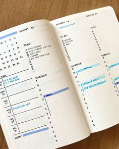 an open planner book sitting on top of a wooden table