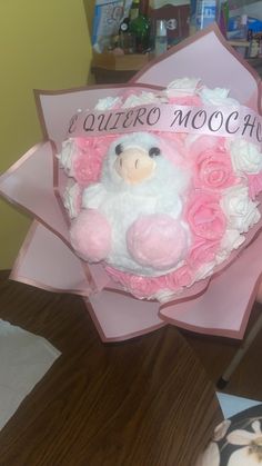 a pink and white teddy bear with roses in it's hair sitting on top of a paper bouquet