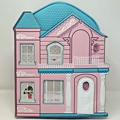 a pink and blue doll house with lots of windows on the front, door and second story