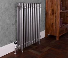 an old radiator in the corner of a room next to a book shelf