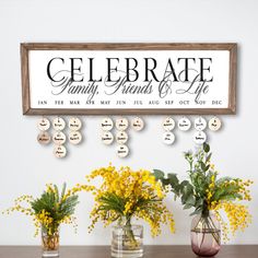 three vases filled with yellow flowers sitting on top of a table next to a sign