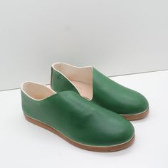 a pair of green shoes sitting on top of a white table