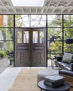 a living room filled with furniture and lots of glass doors that open up to the outside