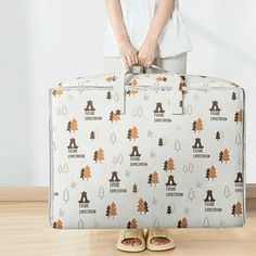 a woman standing next to a suitcase with trees on it