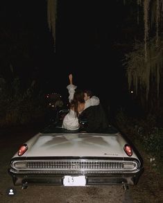 a man and woman sitting in the back of a car