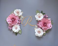 the letter r is surrounded by flowers and leaves on a gray background with gold lettering