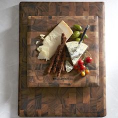 a cutting board topped with cheese and meat