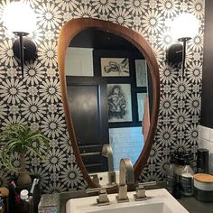 a bathroom sink sitting under a mirror in front of a wall mounted faucet