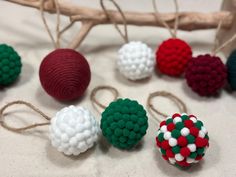 several different colored balls are sitting on a table next to some twine string and wood sticks