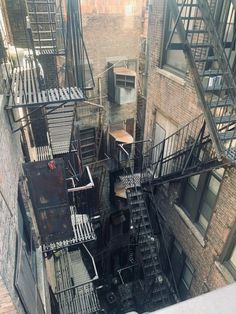 an aerial view of some buildings with stairs and fire escapes on them in the city