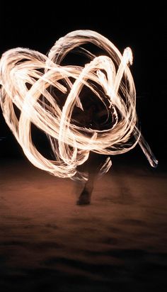 a person is spinning fire in the dark