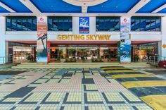 an empty shopping center with colorful tile floors and blue skylights above the store front