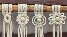 four different ropes with wooden beads hanging from the top one is white and the other two are beige