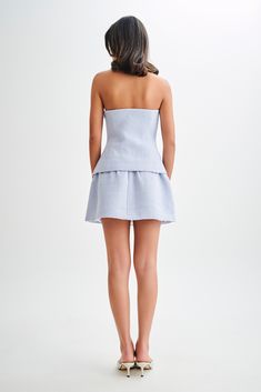 Refined chicThe CYRUS Gathered Boucle Mini Skirt is a stylish and elegant piece perfect for any occasion. This high-waisted mini skirt features a fitted waist yoke panel that accentuates your figure, while the gathered skirt adds a touch of playful sophistication. Crafted from luxurious boucle fabric and fully lined for comfort, it includes a side zip with a hook & eye closure for a seamless fit. Pair it with the Cyrus Strapless Boucle Top for a coordinated and chic ensemble. Fitted High Waist Skirt For Brunch, Elegant Fitted Shorts For Date Night, Chic Mini Skort For Brunch, Chic Flowy Skort For Brunch, Chic Blue Mini Dress With Ruffled Skirt, Fitted Mini Length Shorts For Brunch, Chic Fitted Skort For Day Out, Spring Mini Skort For Date Night, Date Night Lined Mini Skirt