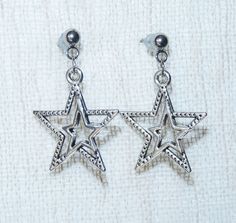 Star earrings. Antique silver tone star charms dangling on stainless steel earring studs with rubber backs. Star size: 23mm x 20mm This listing is for one pair of star earrings with rubber backs. These earrings will come in a gift bag. I offer combined shipping costs which give you a shipping discount for ordering multiple items from my shop. Charm material: Zinc alloy, Nickel safe, Lead free, Cadmium free Earrings care: Take them off while you sleep, do sports activities, bathe, having a shower. Avoid contact with chemicals, high temperatures. Avoid the violent collision and friction. Do not regularly clean jewelry, wipe with a soft cloth to remove stains. Please note: this item will be sent via standard unregistered post.  If you would like to be registered upon check out you can choose Nickel-free Metal Star Earrings, Nickel-free Star-shaped Metal Earrings, Nickel-free Star Shaped Metal Earrings, Silver Star Clip-on Earrings For Gift, Adjustable Star-shaped Metal Earrings, Silver Star-shaped Pierced Earrings, Pierced Star-shaped Metal Earrings, Pierced Metal Star Earrings, Silver Adjustable Star Earrings