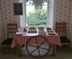 the table is set up for a party with plates and pastries on it, along with other food items