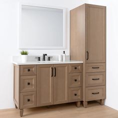 a bathroom with two sinks and cabinets in it