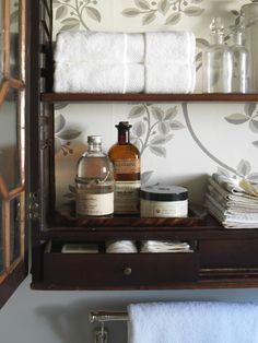 a bathroom shelf with towels and soaps on it