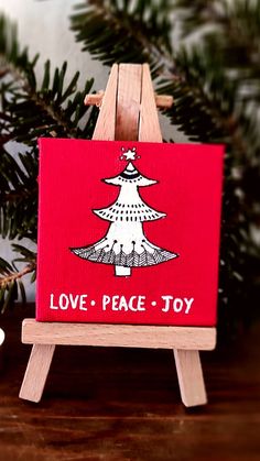 Mini red christmas canvas on easel depicting a christmas tree and "love peace joy" quote. Handmade Christmas Decor, Handmade Christmas Decorations, Christmas Decor Ideas, Decor Items, Handmade Christmas, Gift Baskets, Peace And Love