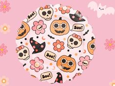 a paper plate decorated with skulls, flowers and bats on a pink background that says boo