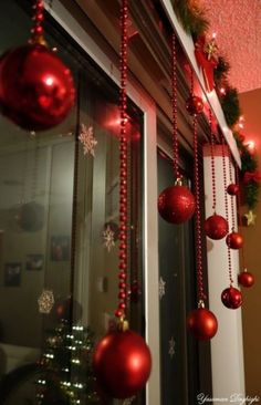 christmas decorations hanging from the side of a window