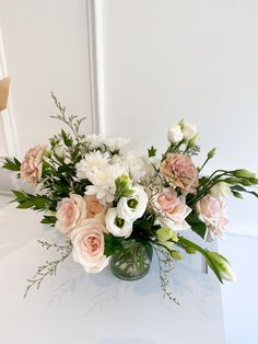 a vase filled with lots of white and pink flowers