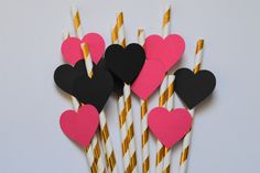 paper straws with hearts on them are lined up in pink, black and white