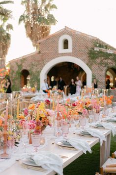 a long table is set with flowers and candles for an outdoor wedding reception at the resort