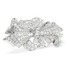 Description: This vintage Art Deco platinum brooch has been exquisitely crafted and cared for. This piece has been molded into a sensuous ribbon inspired motif exhibiting multiple layers of fabric blooming from its center. The brooch's surface is completely encrusted with natural diamonds. There are a total of 132 diamonds weighing approximately 5.00 carats total. There is a methodical mixture of baguette, single and old mine cut diamonds which are bead set, channel set and bezel set displaying Classic White Gold Brooches For Evening, Formal White Gold Platinum Brooches, Elegant White Gold Brooches For Evening, Elegant White Gold Evening Brooches, White Brilliant Cut Brooches For Wedding, White Brilliant Cut Wedding Brooches, Elegant Silver Platinum Brooches, Luxury White Gold Brooches For Wedding, Exquisite Evening Diamond Brooches