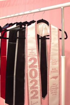 three ties hanging on a rack in front of a pink wall with the word 2009 written on it