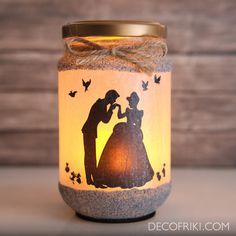 a lit candle with an image of a man and woman on it