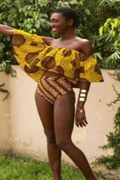 a woman in a yellow and brown swimsuit is holding her arms out to the side