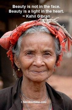 an old woman wearing a red headdress with a quote on the side that reads beauty is not in the face beauty is a light in the heart