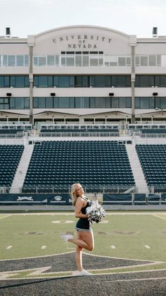 a cheerleader is on the field in front of an empty stadium