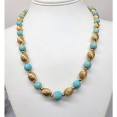 This is part of Chairish’s Costume Jewelry assortment.  1960s goldtone ovoid textured beads and round molted faux-turquoise single strand beaded necklace with push pin clasp. Marked "NAPIER" on the pin part of the clasp. Center bead measures 1/2 inch across. Interior circumference is 19 3/4 inches. Condition: Very good; minor wear if any. Gold Turquoise Necklace With Round Beaded Details, Vintage Beaded Turquoise Necklace With Round Beads, Gold Turquoise Necklace With Round Gemstone Beads, Vintage Turquoise Necklace With Round Gemstone Beads, Vintage Turquoise Single Strand Necklace, Vintage Turquoise Single Strand Beaded Necklace, Vintage Turquoise Beaded Necklaces With Round Beads, Vintage Turquoise Polished Beads, Gold Beaded Necklace With Polished Beads