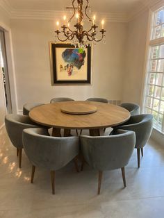 a dining room table with six chairs and a chandelier hanging from the ceiling