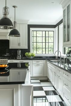 a kitchen with black and white checkered flooring, stainless steel appliances and pendant lights