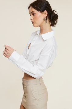 This White Giselle Shirt is the perfect addition to your wardrobe. With a cinched waist and overlap stitching details, it creates a lengthened torso effect for a unique and flattering look. The perfect cropped fit makes it a great standalone top. Elevate your style with this one-of-a-kind button-up. Fabric & fit: 80% nylon 20% cotton Model is wearing size Small. Trendy Cropped Shirt For Spring, Spring Workwear Tops With Cropped Hem, Chic Fitted Crop Top With Cropped Hem, Chic Button-up Crop Top For Spring, Chic Fitted Cropped Shirt For Fall, Chic Cropped Shirt With Cropped Hem For Spring, Chic Fitted Fall Cropped Shirt, Fitted Button-up Chic Crop Top, Chic Slightly Cropped Shirt For Spring