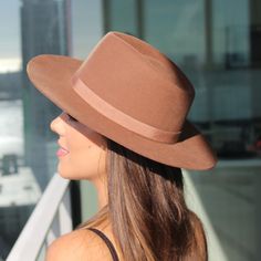 Teak brown unisex fedora hat in the Rancher style look. Sambboho's Blake hat has a hard brim and indented crown. This design has a vintage inspired silhouette with a soft grosgrain ribbon. It will provide high UV protection rated at 50+ UPF. This designer hat is very high end, handmade by our artisans with 100% Brazilian wool. This hat is unisex. You will be amazed by the quality. The timelessness chic and sophistication exuded by this hat make it a lifetime wardrobe investment you’ll never regr Brown Top Hat With Curved Brim For Rodeo, Fitted Brown Panama Hat With Flat Crown, Vintage Fedora With Curved Brim For Fall, Brown Fitted Fedora For Kentucky Derby, Brown Wide Brim Top Hat For Rodeo, Brown Short Brim Top Hat For Rodeo, Western Brown Fedora With Flat Crown, Western Style Brown Fedora With Flat Crown, Western Style Brown Hat With Flat Crown