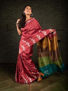 The USP of this saree is its aanchal. The multicolour aanchal is in contrast with the body of the saree. Its crimson red colour is contrasting which makes it alluring. Minimal discharge of leaf print makes it look beautiful. The floral pattern suggests that it is a nature-centric saree. Beautiful discharge printing on dark brick red colour makes it popular among saree lovers. Its multicolour  aanchal highlights the entire saree. So, it's a great example of how an exclusive block printing on pure gachi tussar silk saree from Bengal should be. WEIGHT: 450 gm COLOUR: Crimson Red CRAFT: Traditional Style of Hand Block printing DIMENSIONS: Saree length 6.5 Mts., Saree width 1.14 Mts. Blouse piece inclusive. MOTIF: Floral PRODUCT MATERIAL: Handwoven Gachi Tussar Silk saree WASH INSTRUCTIONS:  Dr Discharge Printing, Saree Beautiful, Red Crafts, Red Saree, Saree Trends, Indian Textiles, Tussar Silk Saree, Crimson Red, Saree Dress