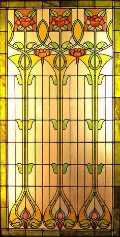 a stained glass window with flowers and leaves on it's sides, in the middle of