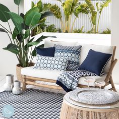 a white couch sitting on top of a wooden table next to a potted plant