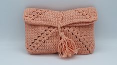 a pink crocheted purse with tassels