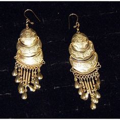 Half-moon gold earrings etched with the image of villagers and animals. Antique Engraved Drop Earrings, Antique Ceremonial Earrings, Antique Gold Engraved Earrings, Antique Gold Chandelier Earrings In Brass, Vintage Engraved Dangle Earrings, Ceremonial Brass Drop Earrings, Traditional Engraved Yellow Gold Earrings, Antique Gold Earrings With Latkans, Ornate Bronze Earrings