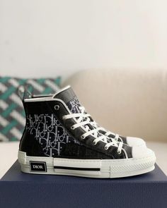 Embrace a blend of classic and contemporary style with these high-top sneakers inspired by the iconic Dior B23. Featuring a sleek black upper adorned with the signature Dior Oblique pattern, these shoes exude understated luxury. The contrasting white sole with a black stripe adds a sporty touch, while the high-top silhouette provides ankle support and a fashion-forward edge. Luxury High-top Sneakers With Contrast Sole, Luxury High-top Sneakers With Contrast Sole For Streetwear, Luxury Lace-up High-top Sneakers With Contrast Sole, Designer High-top Sneakers With Vulcanized Sole, Luxury High-top Sneakers With Boost Midsole For Streetwear, Luxury Lace-up High-top Sneakers With Vulcanized Sole, Luxury High-top Sneakers With Vulcanized Sole, Designer High-top Sneakers With Contrast Sole, Modern High-top Custom Sneakers With Branded Heel