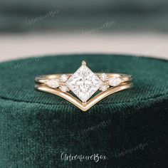 a diamond ring sitting on top of a green velvet box